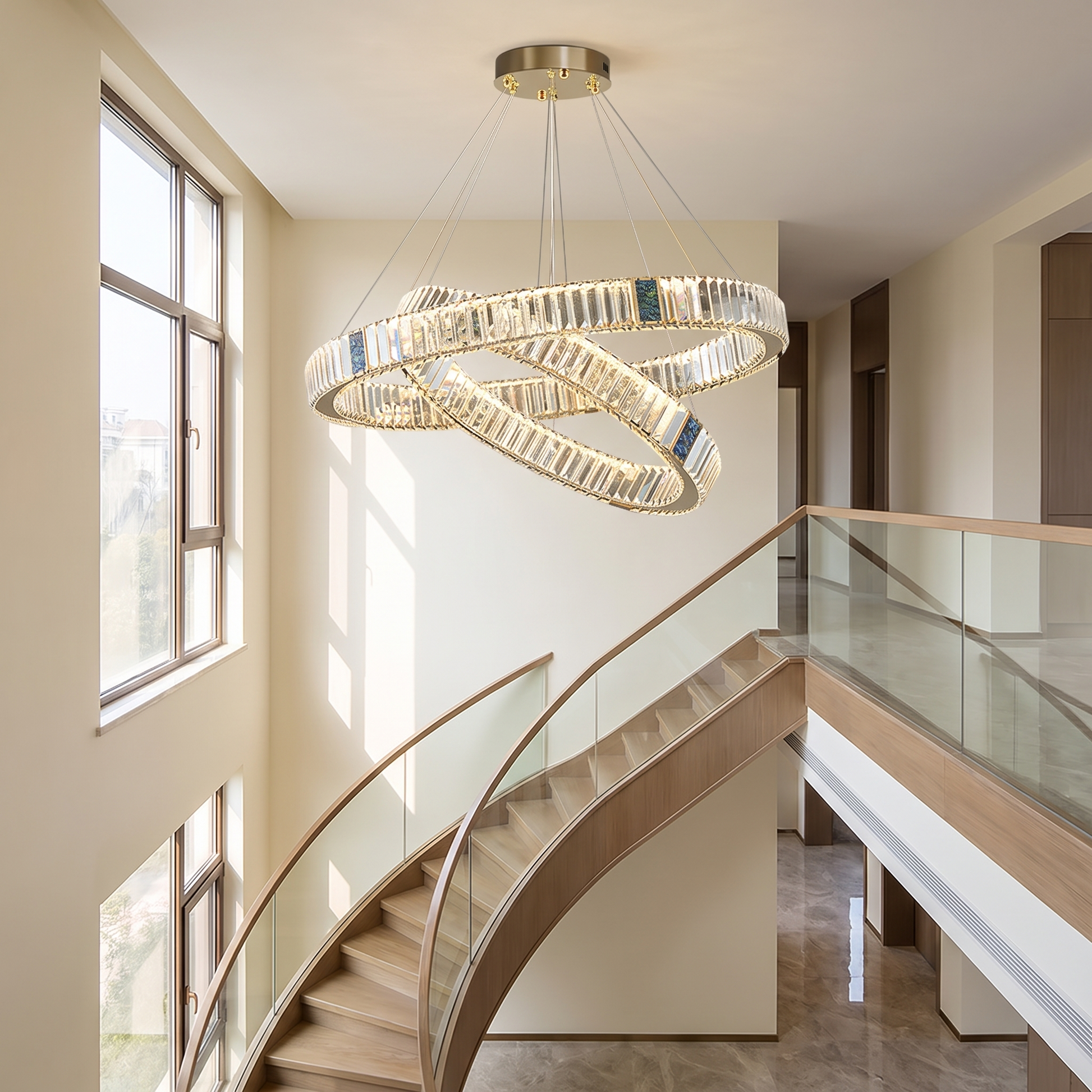 Luxury crystal chandelier suspended in a double-height entryway stairwell