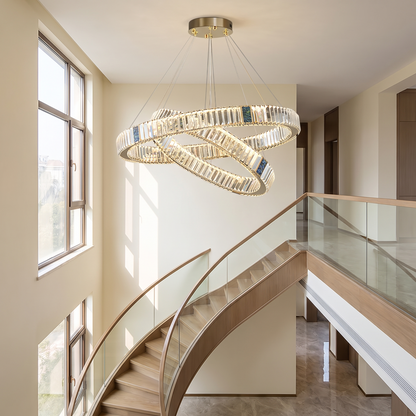 Luxury crystal chandelier suspended in a double-height entryway stairwell