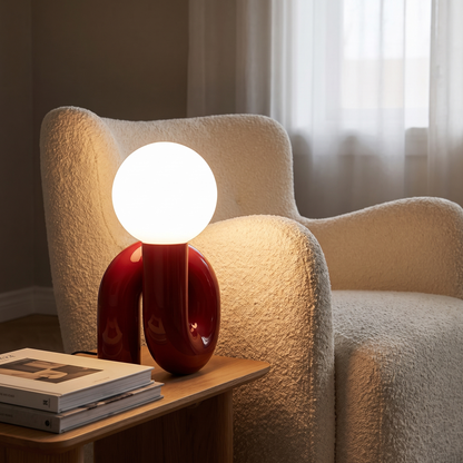 Resin table lamp in red beside a living room armchair