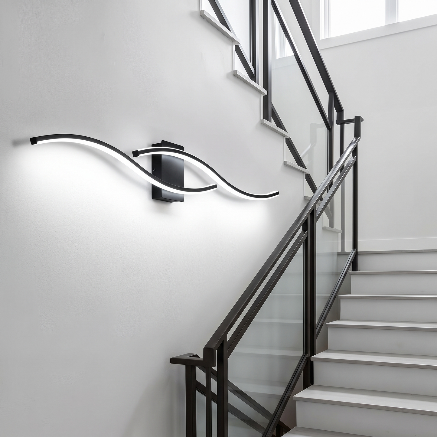 Black LED wave wall sconce with cool white light in a stairwell
