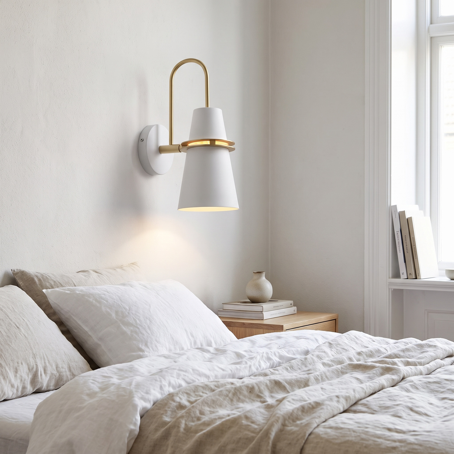 White Nordic wall sconce beside a bed