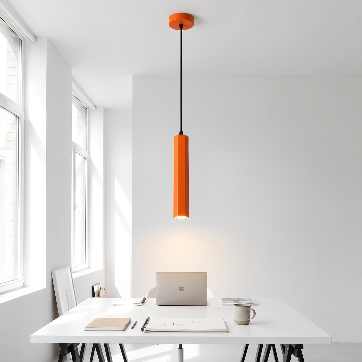 Orange geometric LED pendant light above a studio desk