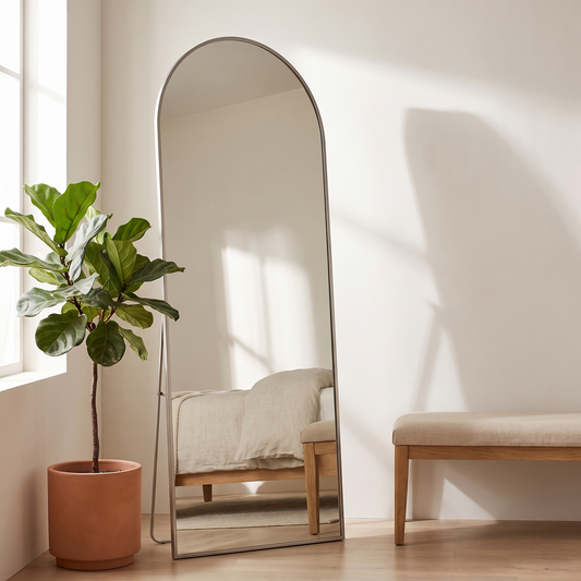 Silver arched standing mirror in a warm white bedroom