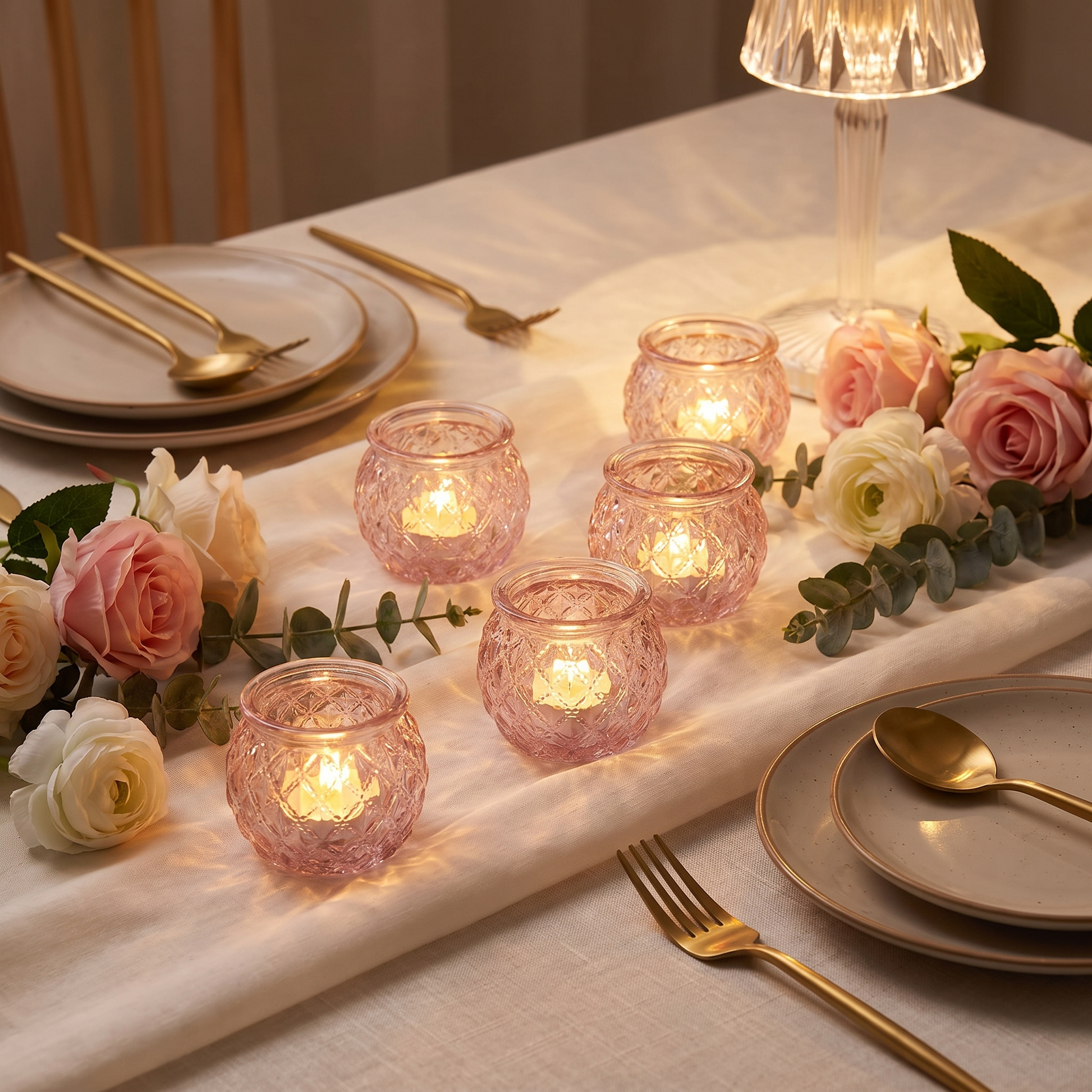 Pink glass votive candle holders on a romantic dinner table