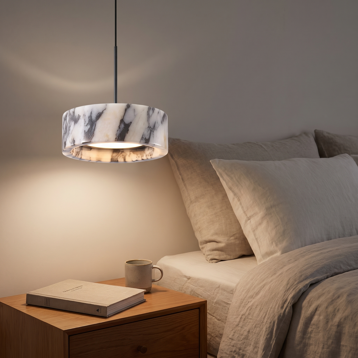 Marble drum pendant light beside a bed as a bedside pendant