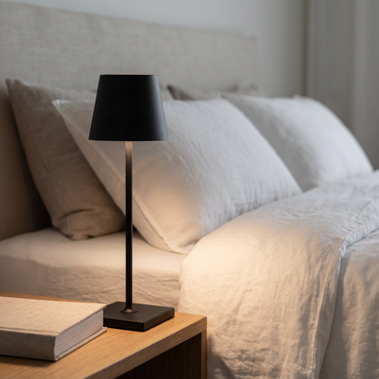 Cordless table lamp on a bedside table at night