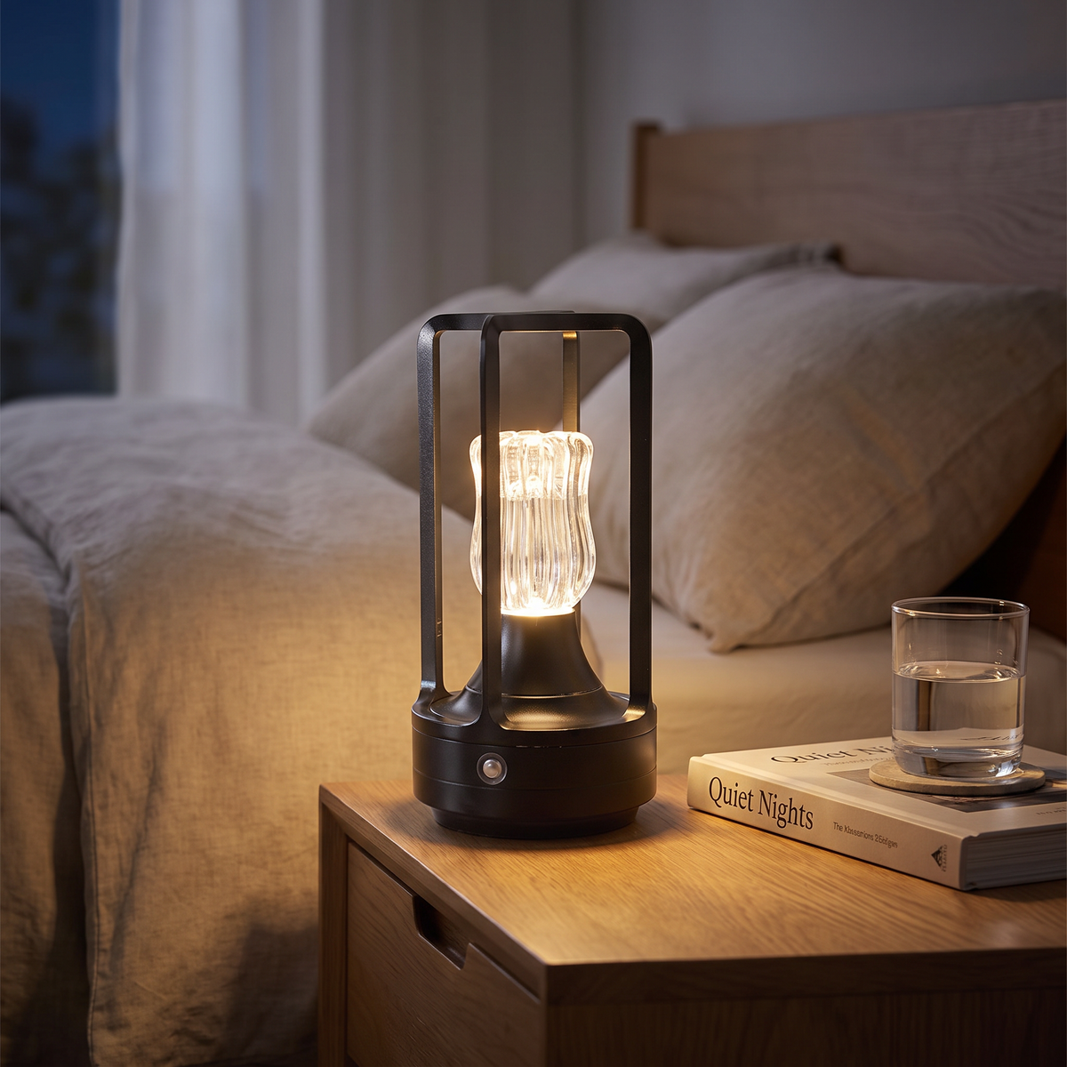 Black cordless crystal table lamp on a bedside table