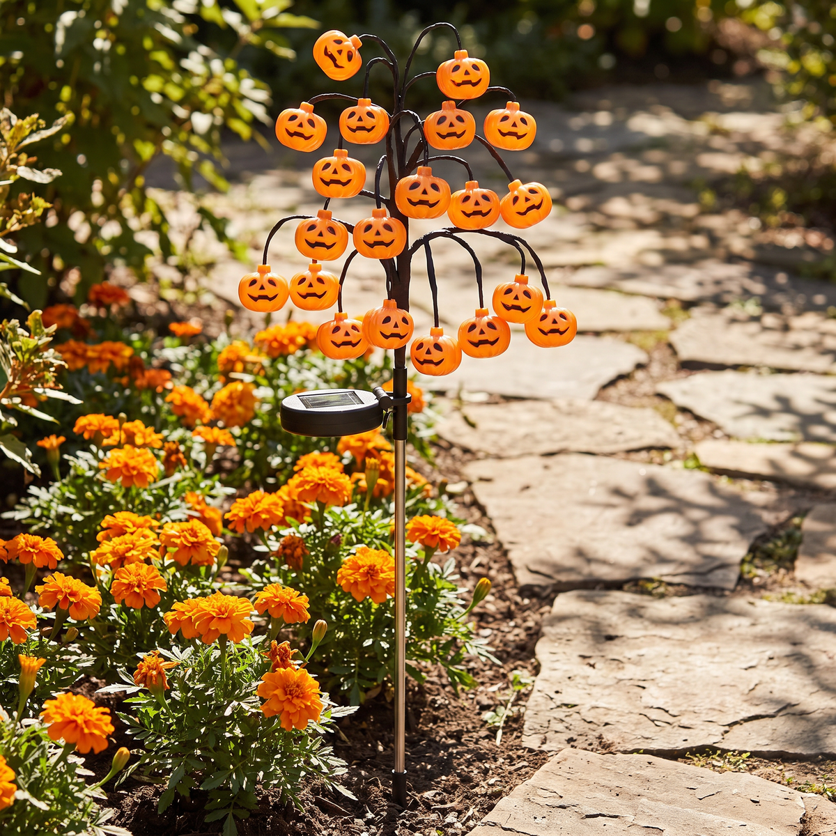Solar pumpkin branch light in a marigold bed by day